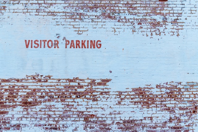 Nápis na stene “visitors parking”